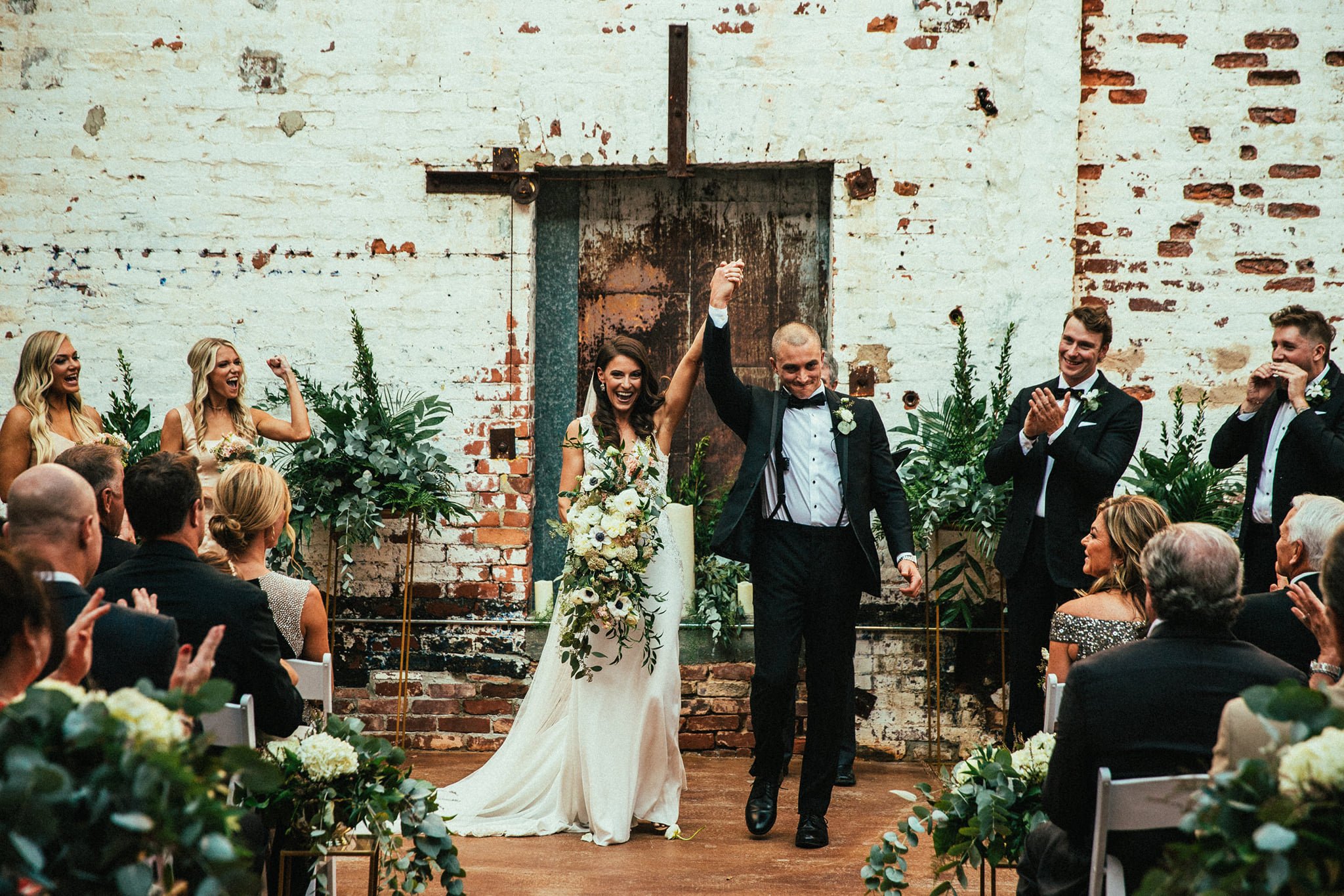 bride and groom cheer after wedding ceremony at The Engine Room in Monroe, GA